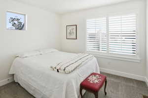 Bedroom with multiple windows and dark carpet