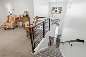 Staircase featuring carpet, hanging lights, and a high ceiling