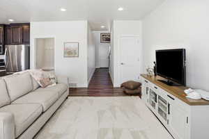 Living room with recessed lighting and dark wood-type flooring