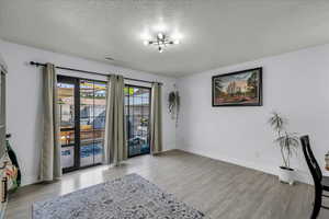 Unfurnished room with light wood-style flooring and a textured ceiling