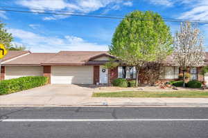 Ranch-style home with brick siding, driveway, a garage, and a tile roof