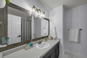 Full bathroom with curtained shower and vanity