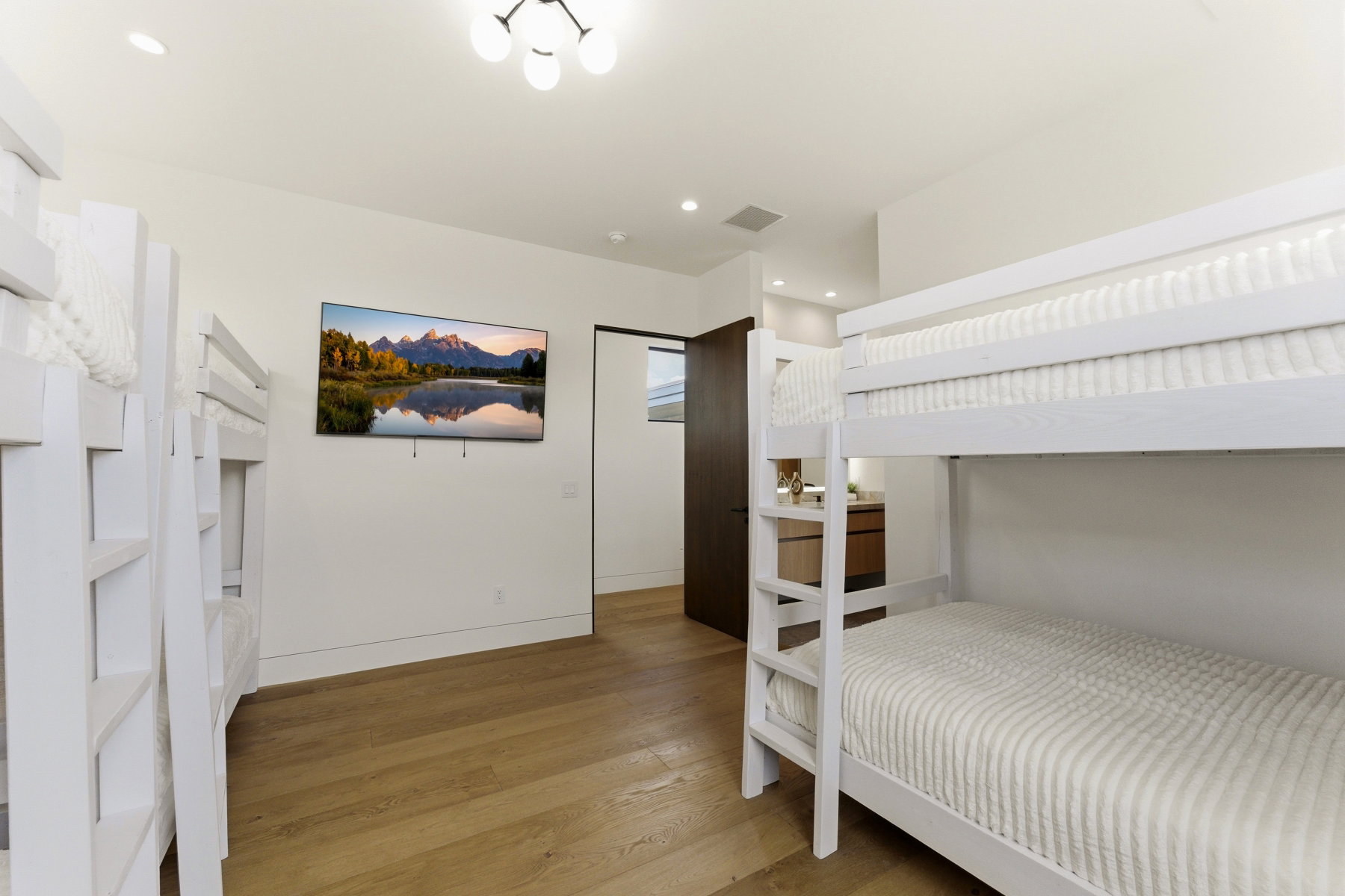 Bright room featuring wood-finish flooring, recessed lighting, and a modern ceiling fixture