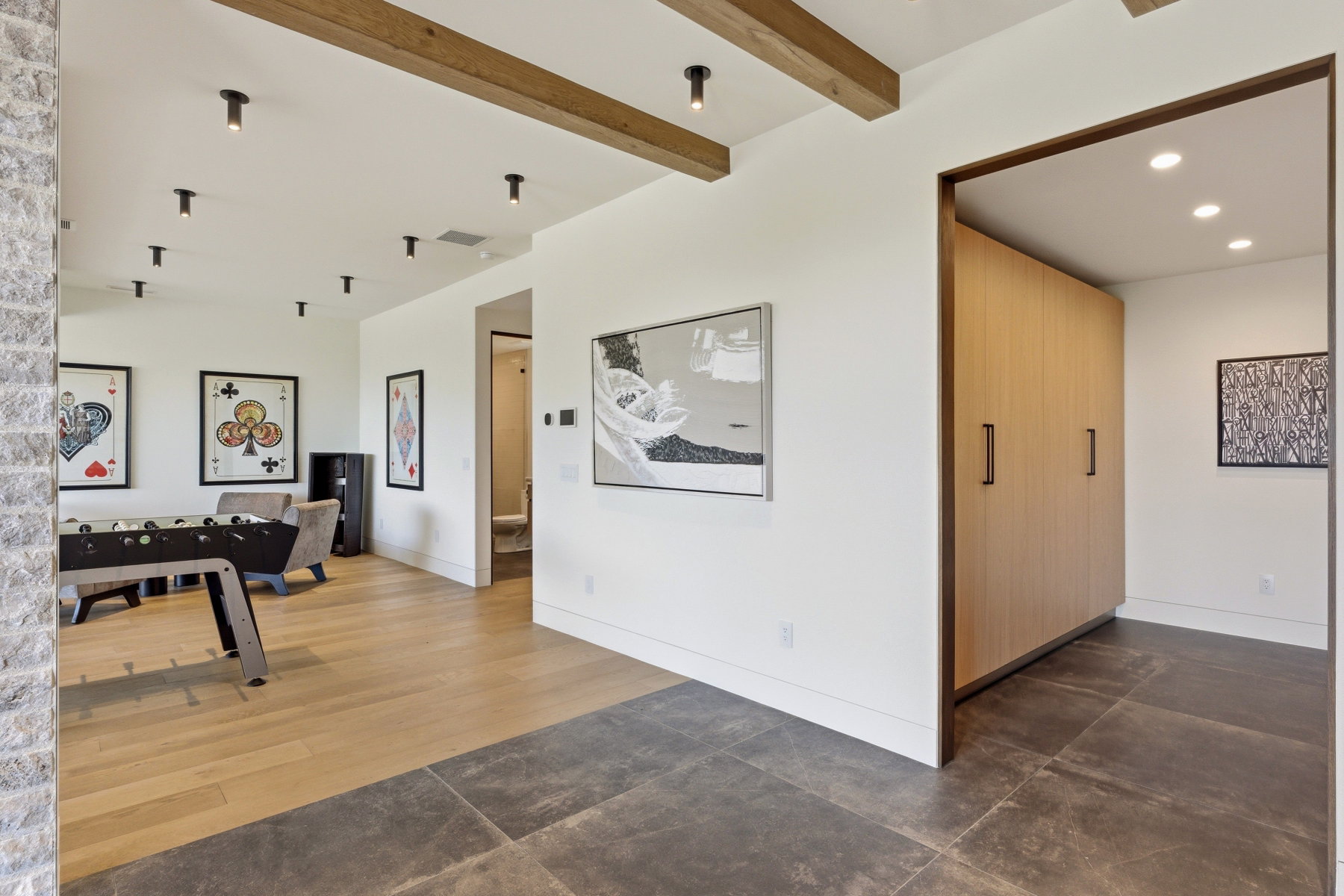 Multi-material flooring featuring large format dark tile and wood-finish planks