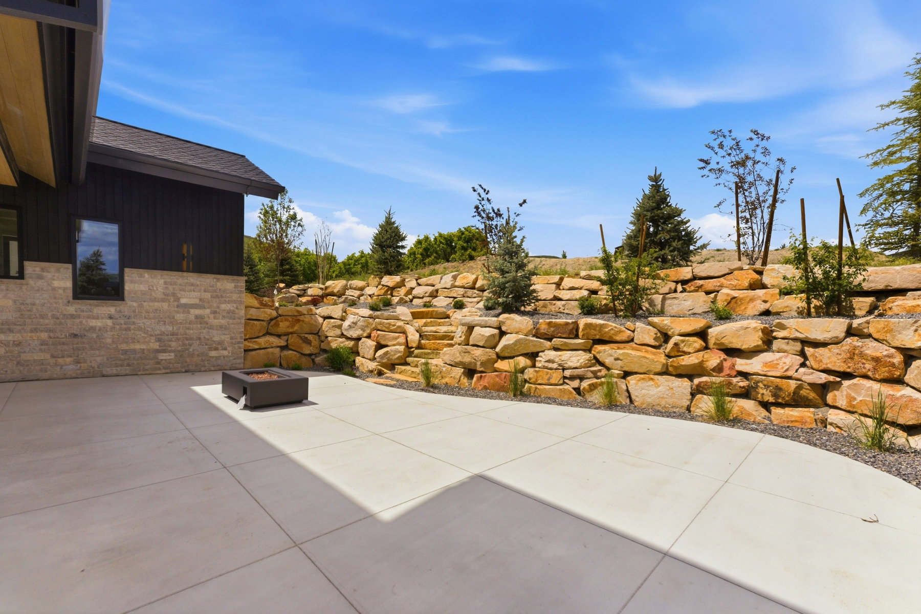 Expansive concrete patio featuring a built-in fire pit