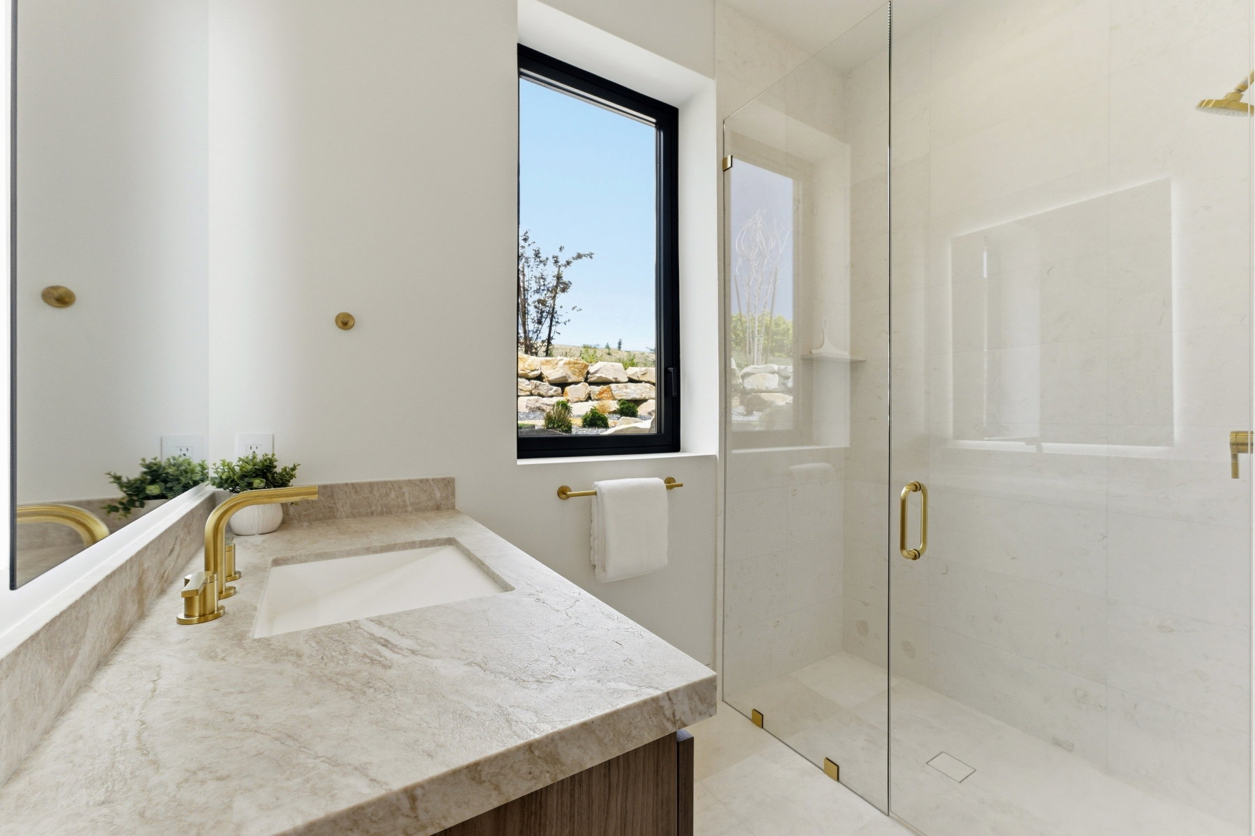 Bathroom featuring a built-in vanity with a stone countertop, an undermount sink, and gold-finish fixtures