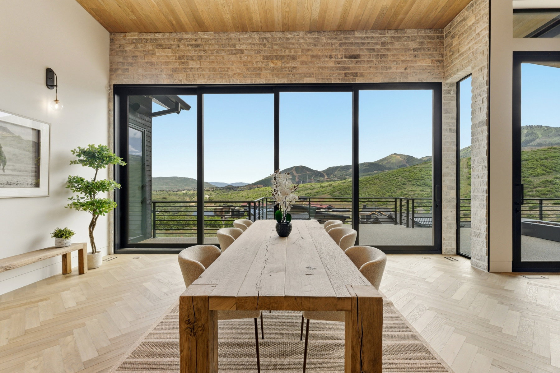 Expansive sliding glass doors showcase mountain and valley scenery