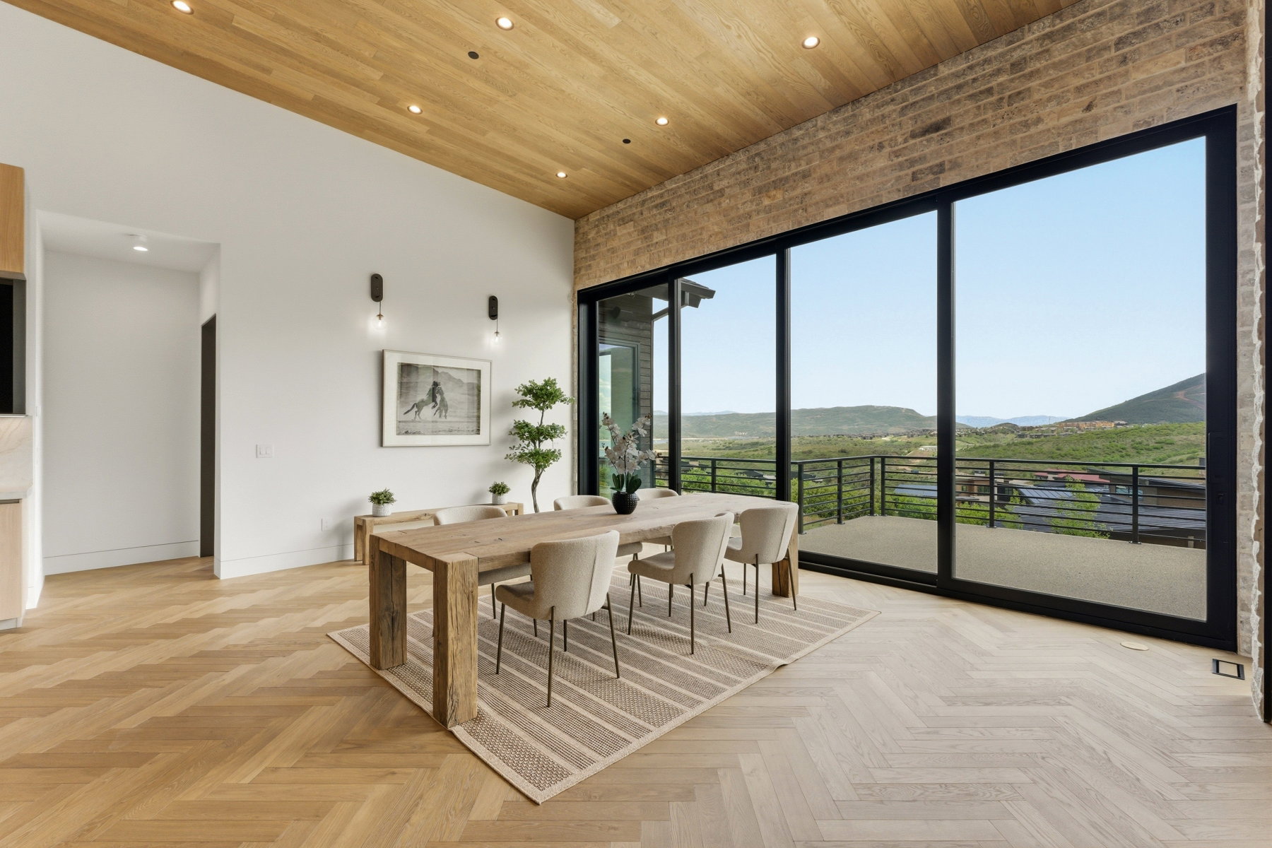 Dining space featuring a wood-finish plank ceiling with recessed lighting, herringbone wood-finish flooring, and a full wall of floor-to-ceiling glass panel doors