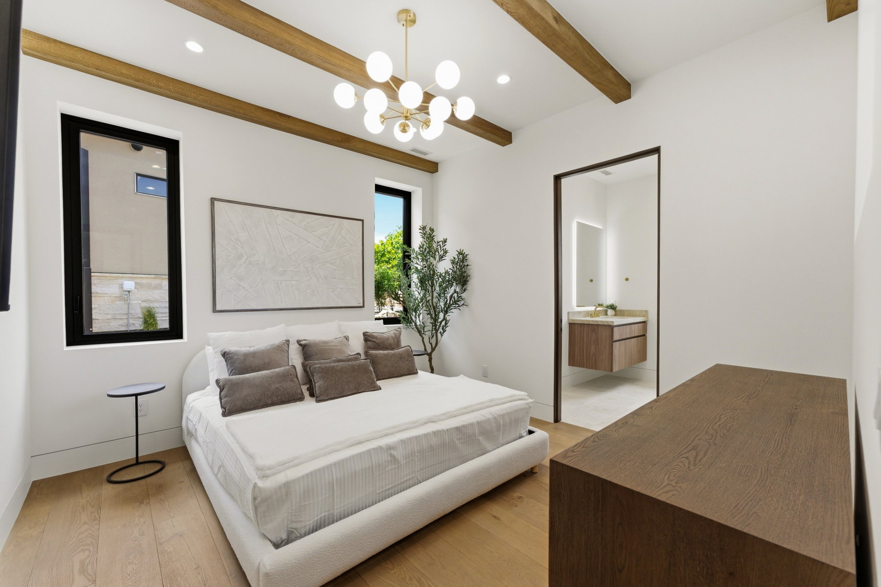 Room featuring exposed wood beams, a modern chandelier, and wood-finish flooring