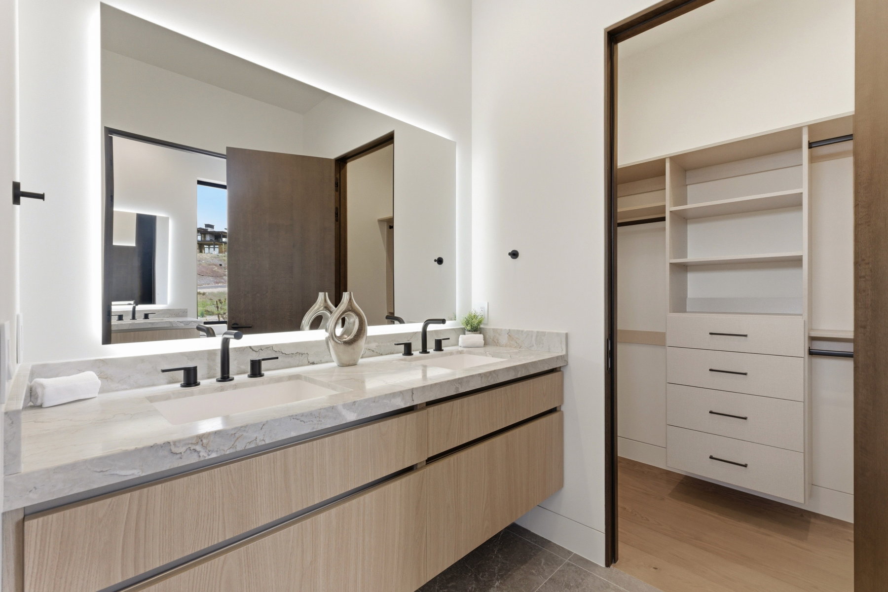 Dual vanity with light-tone wood-finish cabinetry and matte black hardware