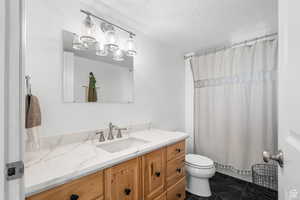 Full bathroom featuring vanity, a shower with shower curtain, and a textured ceiling
