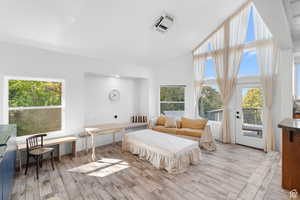 Large family room with wood finish floors, access to exterior, vaulted ceiling