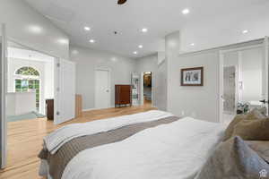 Master bedroom with a spacious closet, light wood finished floors, recessed lighting, connected bathroom, and a ceiling fan