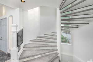 Grand spiral staircase featuring a textured ceiling