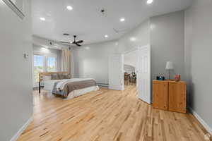 Master bedroom featuring recessed lighting, light wood flooring, ceiling fan, and baseboard heating