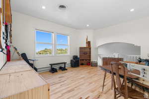 Family room/den/office space with light wood-style flooring, recessed lighting, and a baseboard radiator