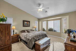 Bedroom with light carpet, vaulted ceiling, and a ceiling fan