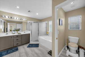 Full bathroom with a bath, a stall shower, double vanity, and recessed lighting