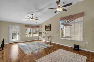Living area with ceiling fan, lofted ceiling, and dark wood-style floors