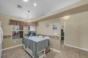 Dining space featuring suspended lighting and light tile patterned flooring