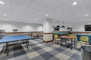 Recreation room featuring a paneled ceiling and recessed lighting