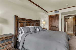 Bedroom with ornamental molding, carpet flooring, and ensuite bathroom