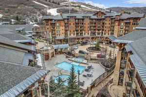 Community pool featuring a hot tub, a mountain view, and a patio