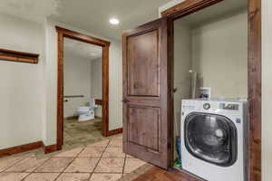Laundry area with washer / dryer, stone tile floors, and recessed lighting