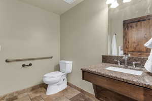 Half bathroom featuring vanity and stone tile floors