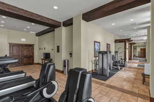 Exercise room with beam ceiling and recessed lighting