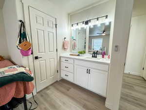 Ensuite bathroom with vanity and light wood-style floors
