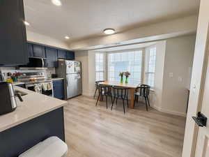 Kitchen with stainless steel appliances, light wood-type flooring, and recessed lighting
