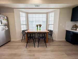 Dining space with light wood-style floors and plenty of natural light