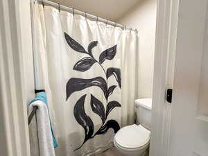 Full bathroom with a shower with shower curtain and toilet