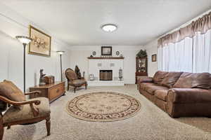 Living area with a brick fireplace and light colored carpet