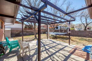 Fenced backyard featuring a patio, a pergola, and a trampoline