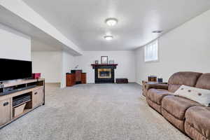 Living area with a fireplace and light carpet