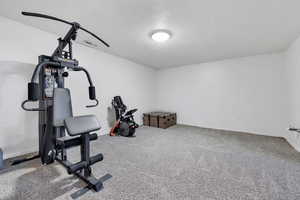 Exercise room with light colored carpet and baseboards
