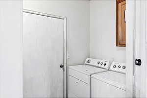 Laundry area with independent washer and dryer and cabinet space