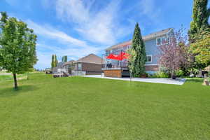View of green lawn featuring a deck and stairway