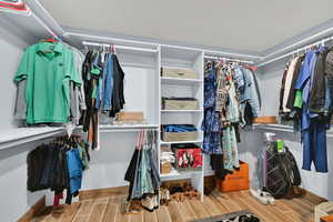 Walk in closet featuring wood finish floors