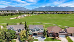 Aerial view of residential area with a mountainous background and a local golf course