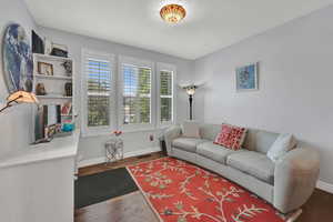 Living area with baseboards and dark wood-type flooring