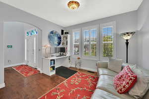 Entryway featuring arched walkways and dark wood-type flooring