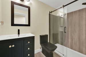 Full bathroom with vanity, a stall shower, and wood tiled floors