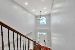 Entrance foyer with suspended lighting, a high ceiling, and plenty of natural light