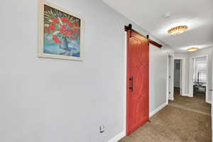 Hall with a barn door and carpet floors