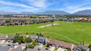 Aerial perspective of suburban area featuring a local golf course and a water and mountain view