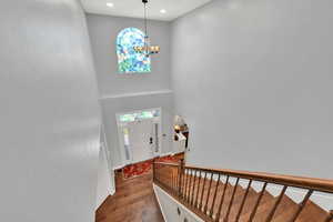 Entrance foyer with a high ceiling, dark wood-style flooring, and suspended lighting
