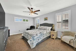 Bedroom featuring dark colored carpet and a ceiling fan
